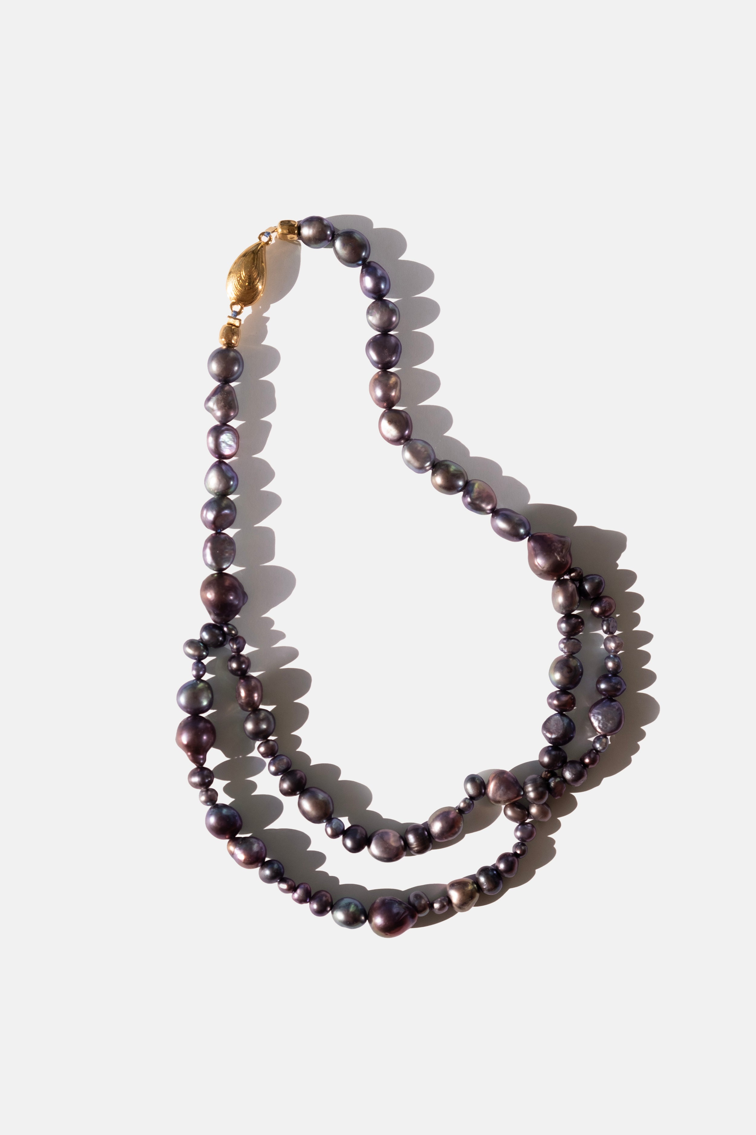 Black Pearl necklace with a gold clasp on a white background