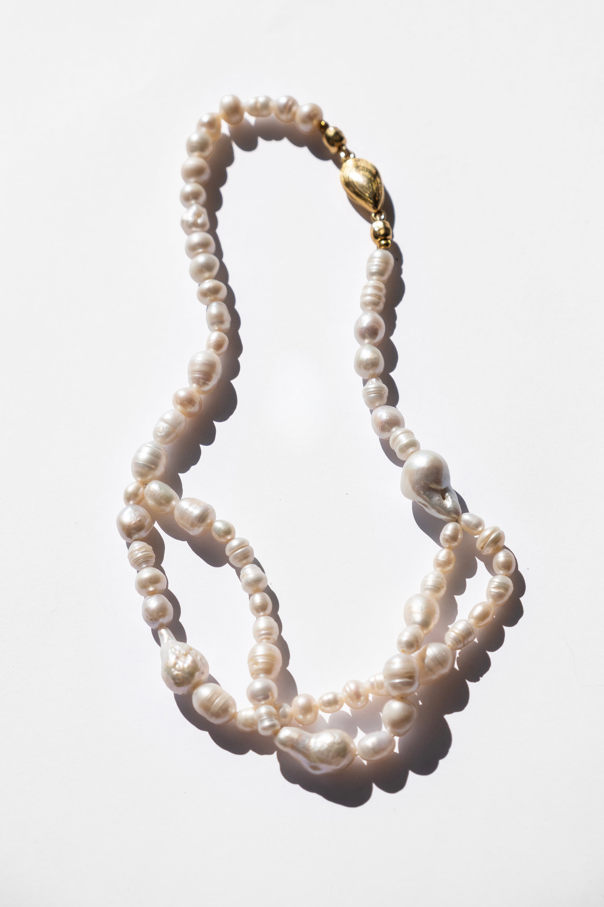 Pearl necklace with a gold clasp on a white background