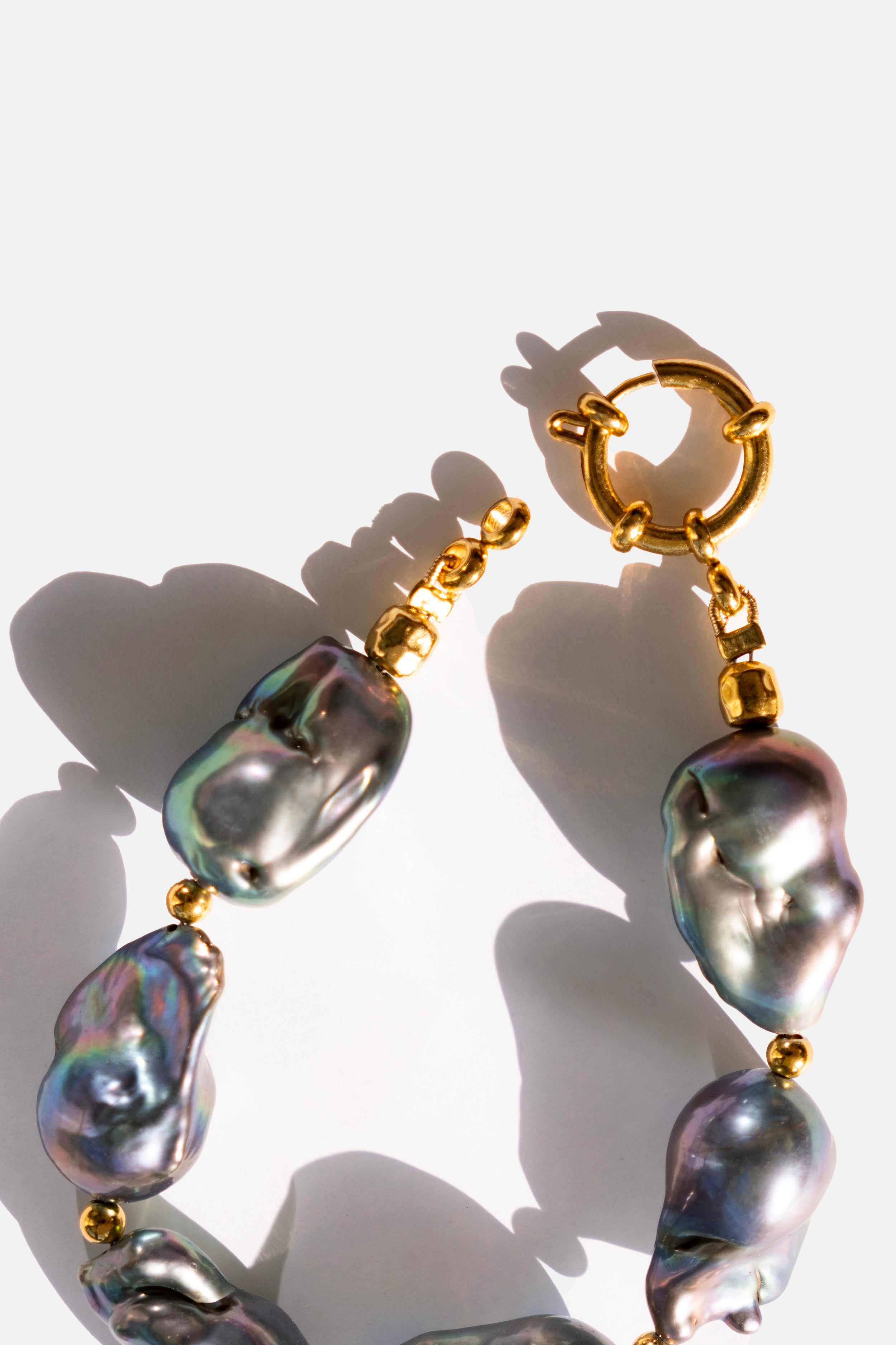 Pearl bracelet with gold accents on a white background