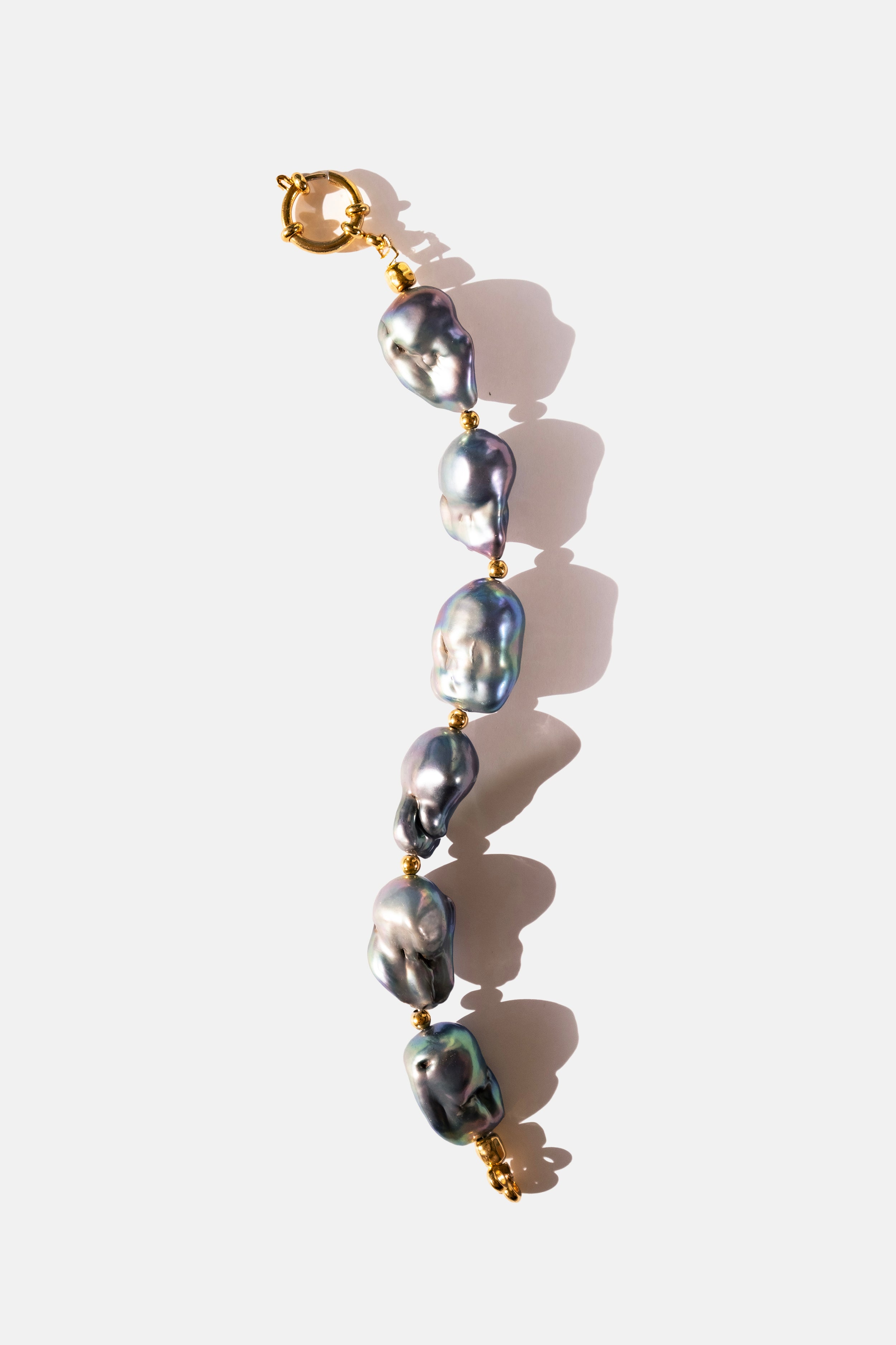 Pearl bracelet with gold clasp on a white background