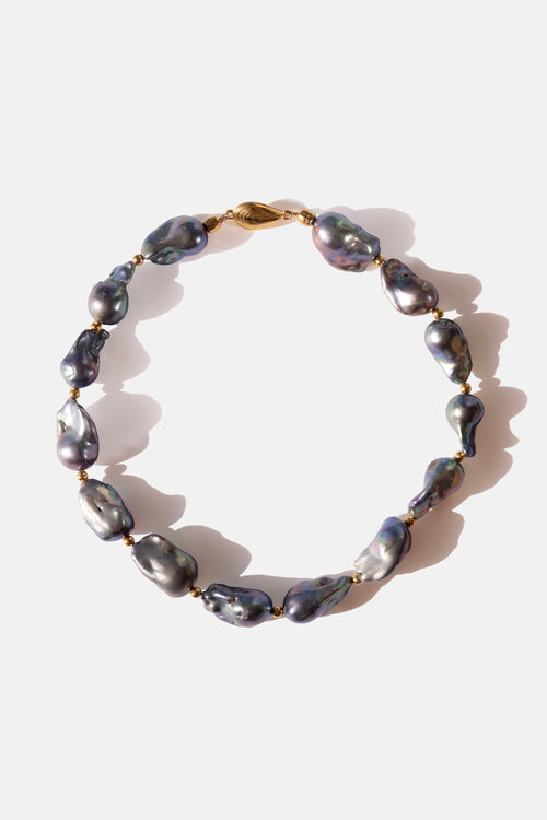 Pearl choker necklace with gold clasp on a white background