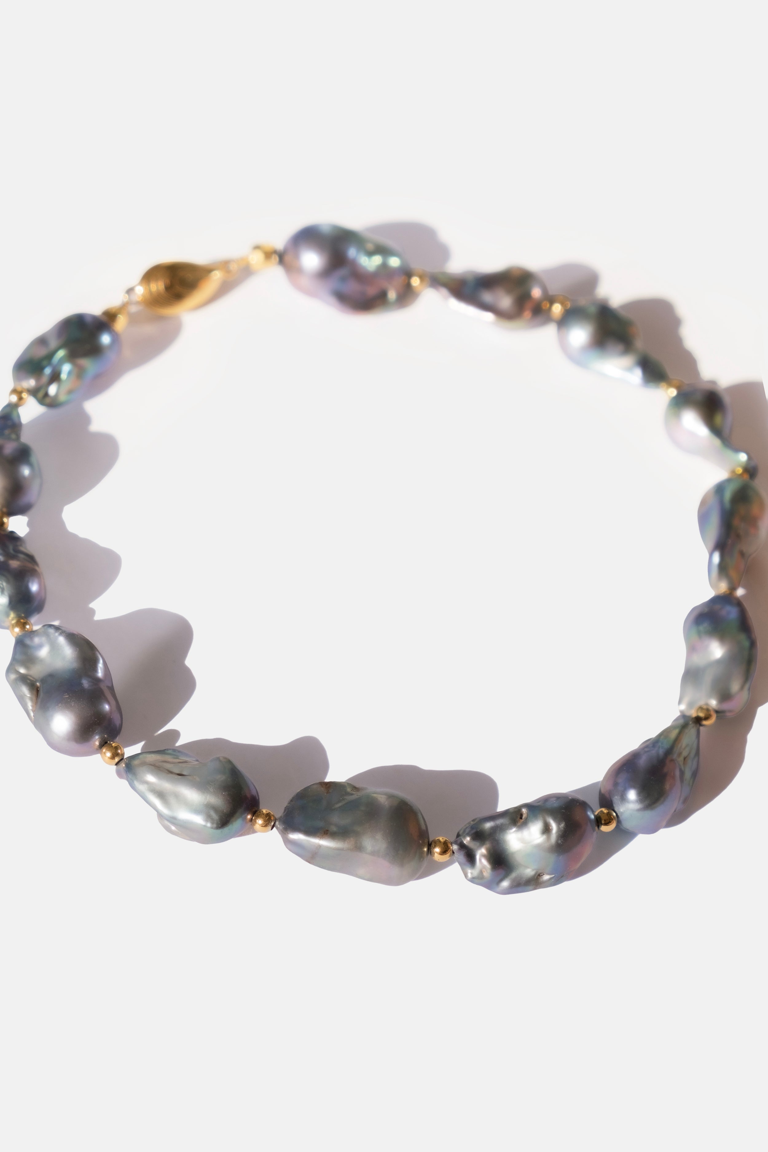 Pearl choker with gold accents on a white background