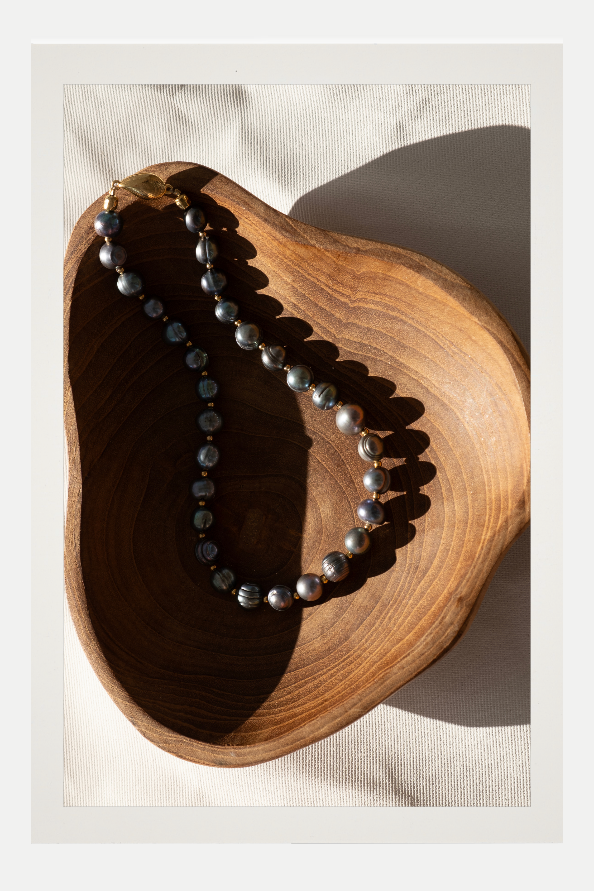 Necklace with black pearls on a wooden surface