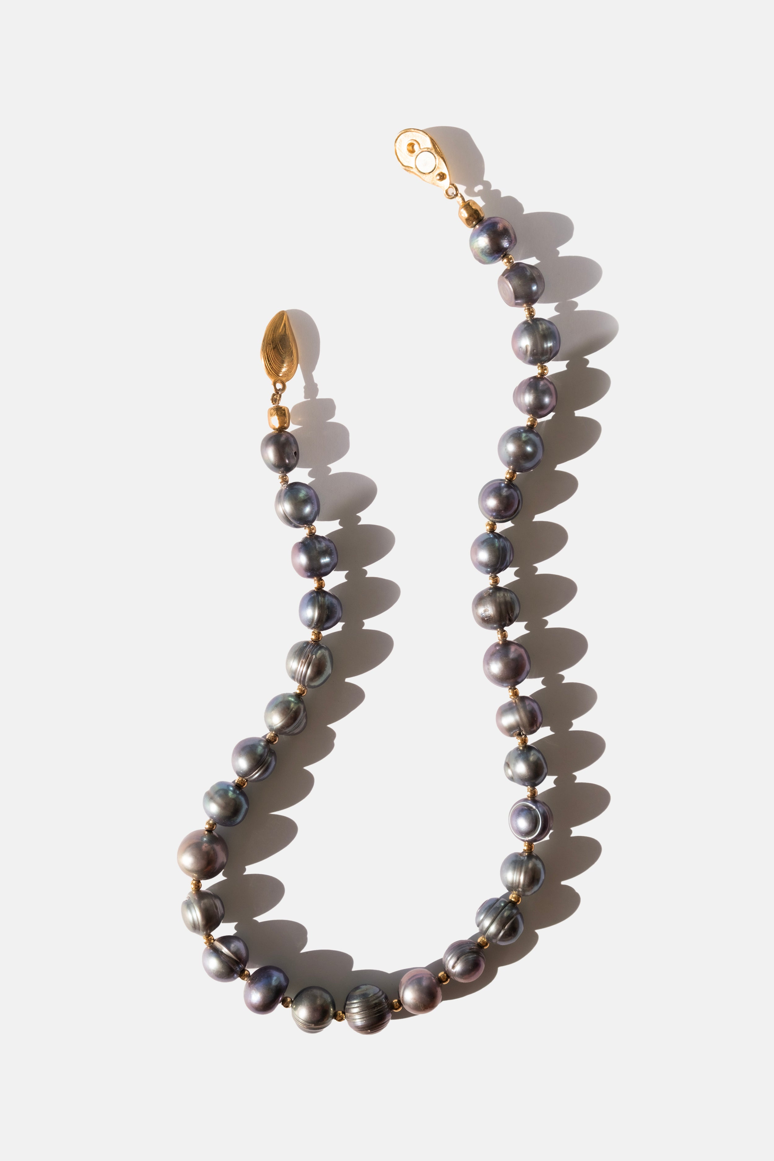 Black Pearl necklace with gold clasp on a white background