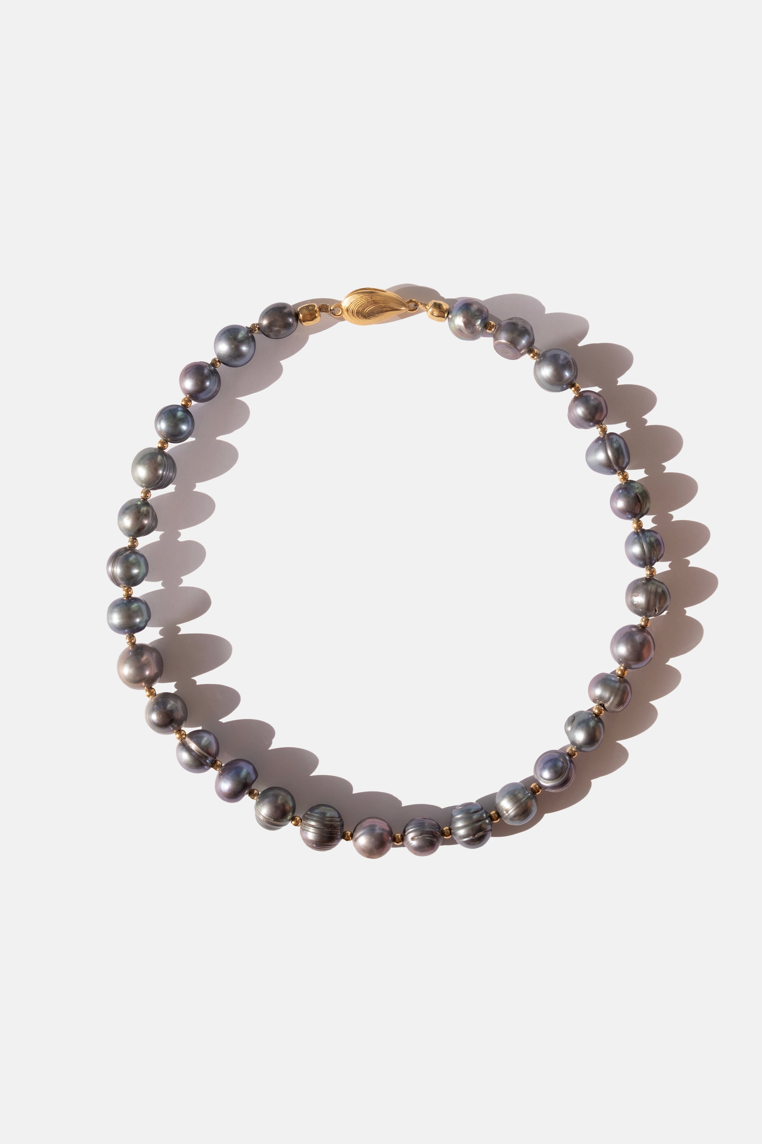 Black Pearl necklace with a gold clasp on a white background