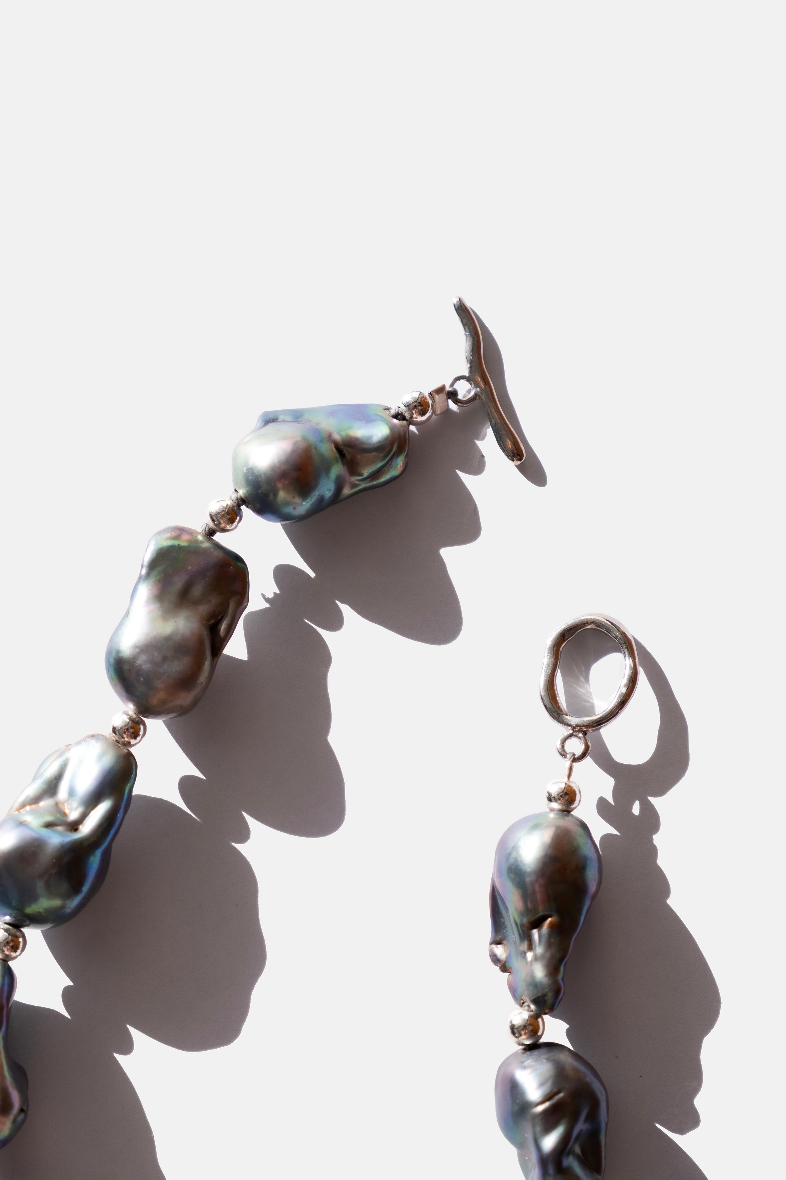 Pearl necklace and earrings on a light background