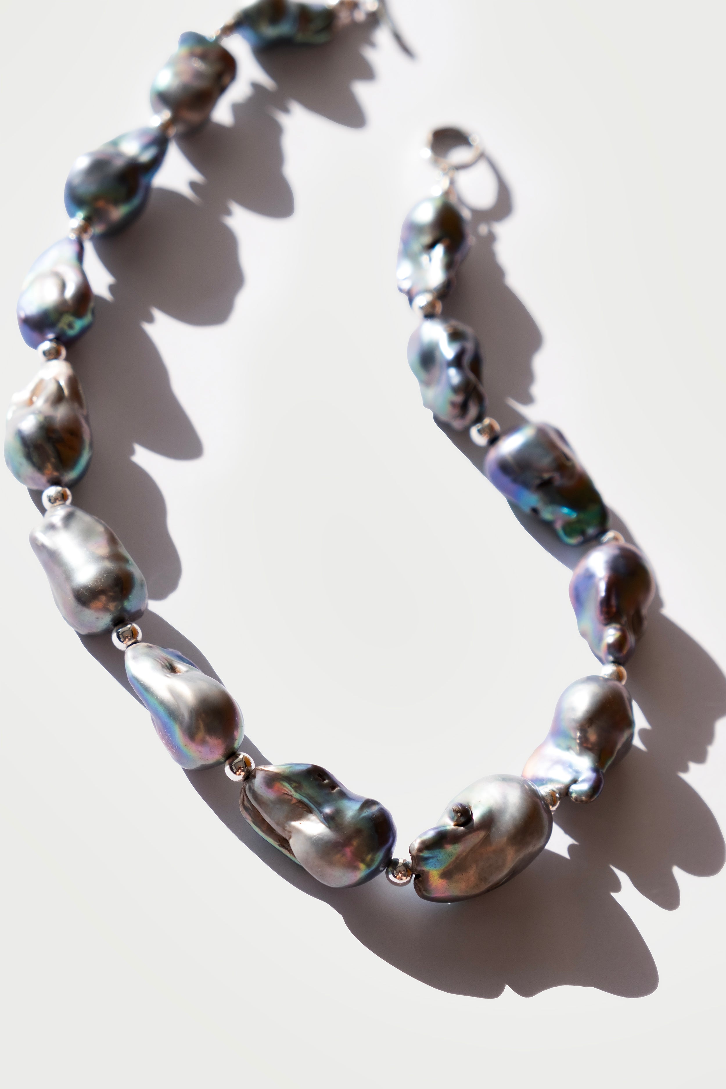Necklace with large, irregularly shaped pearls on a light background