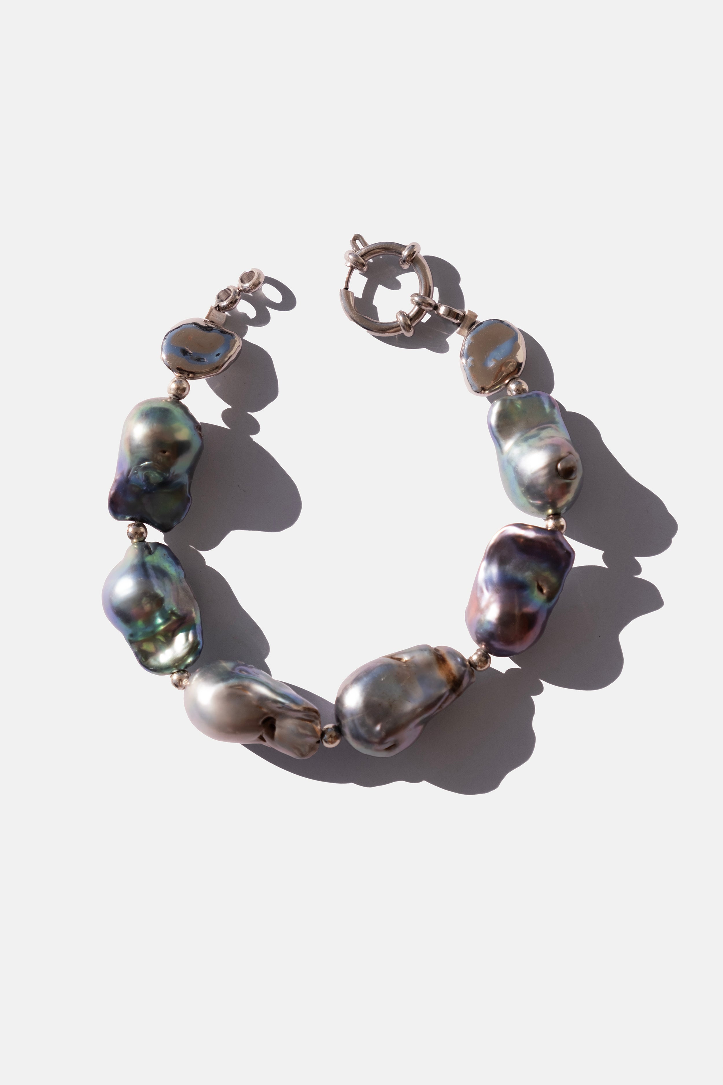 Pearl bracelet with silver clasps on a white background