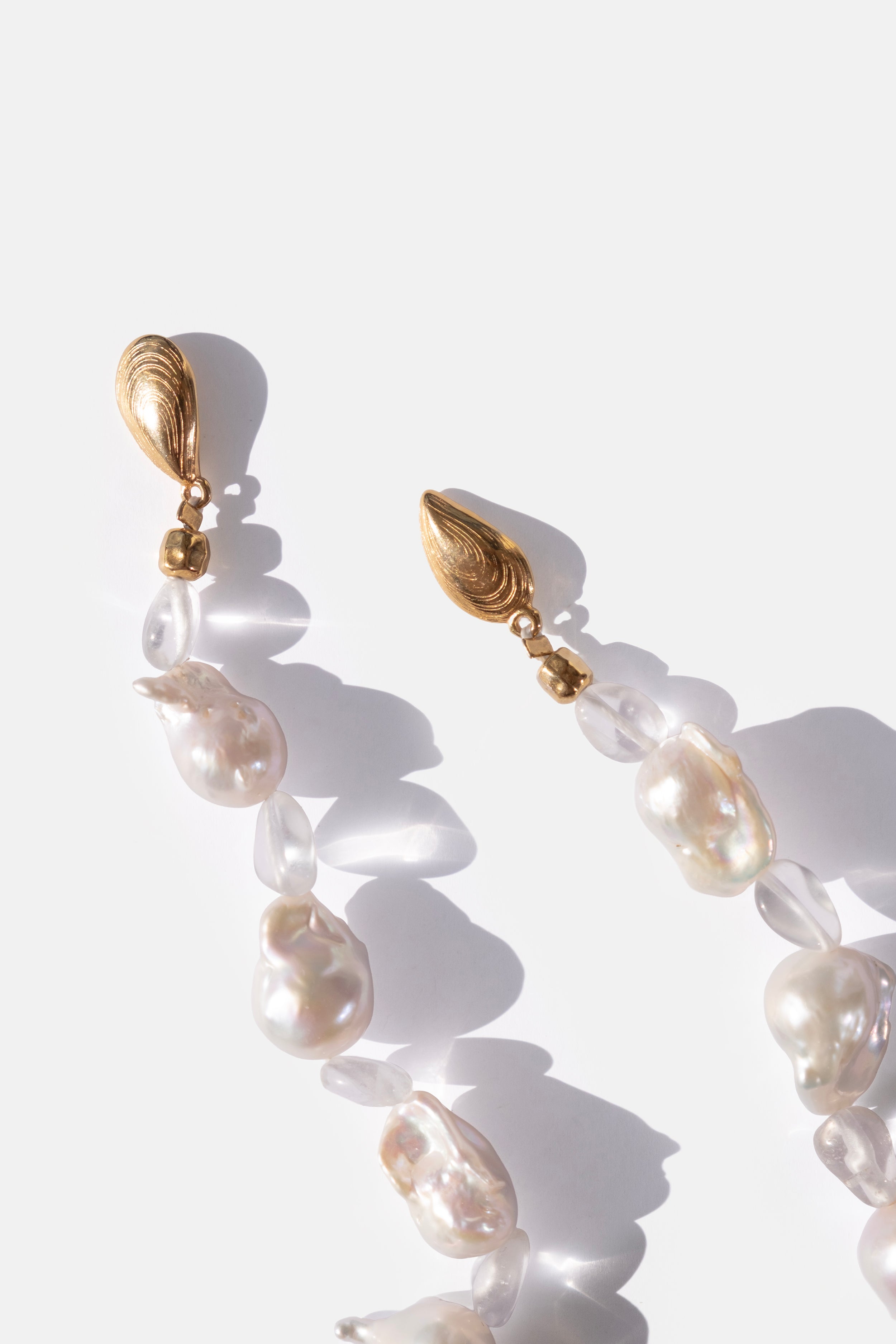 Pearl necklace with gold clasps on a white background