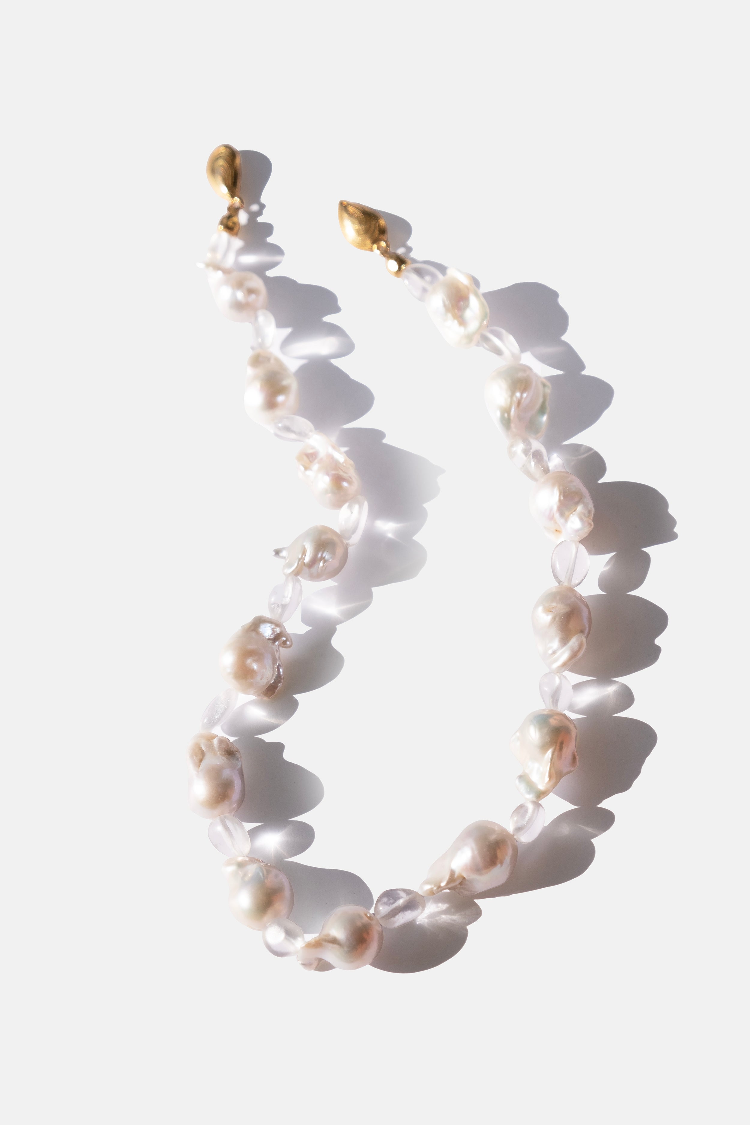 Pearl necklace with gold clasp on a white background