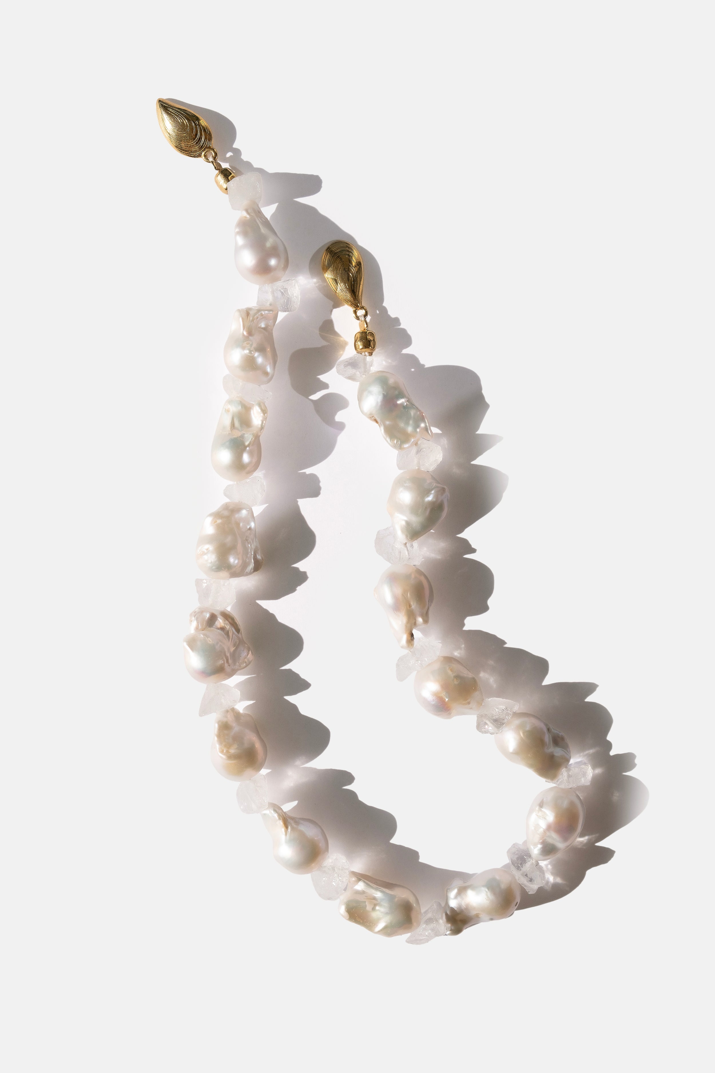 Pearl necklace with gold accents on a white background